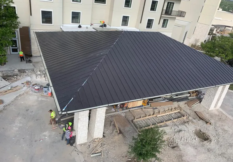 Metal roofing installation team working on a commercial building in Columbus